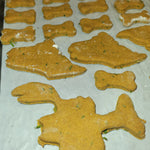 Dog treats shaped like bones on a baking sheet