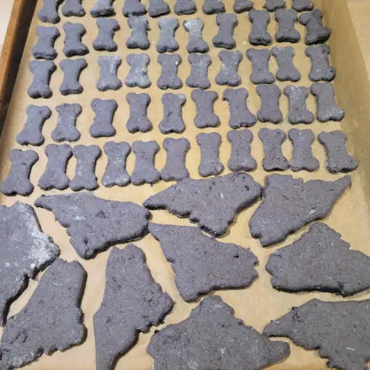 Dog treats shaped like bones on a baking tray